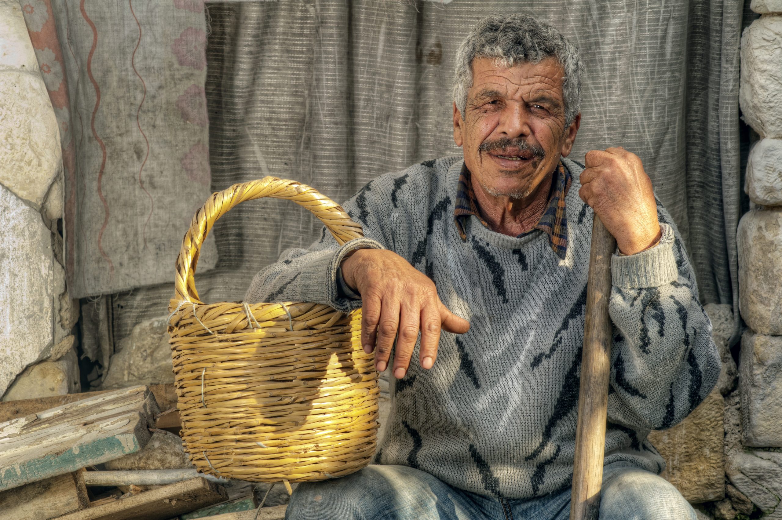 Senior farmer holding a basket and resting